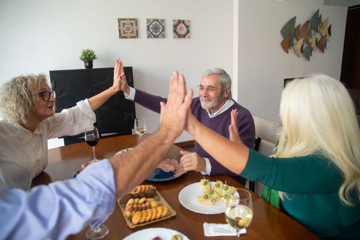Four friends over 50 sharing a relaxed festive meal together