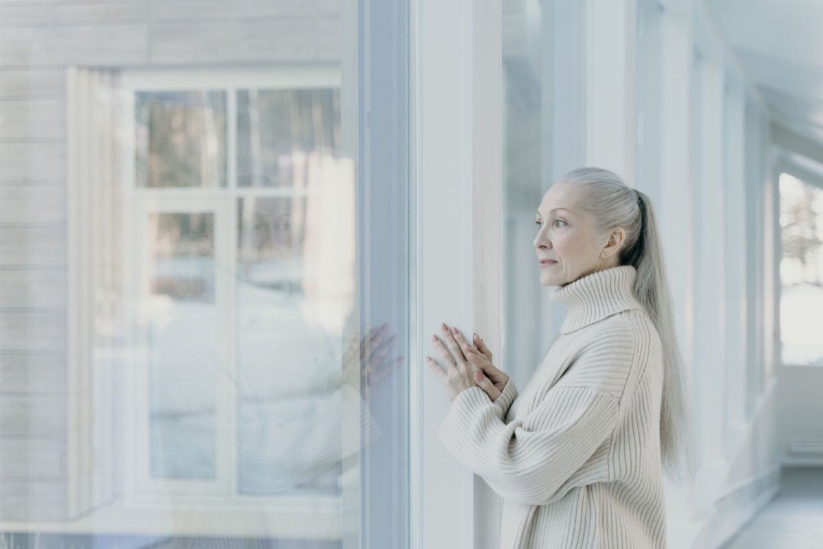 Person over 50 sitting quietly in a calm setting, looking thoughtful and at ease with themselves