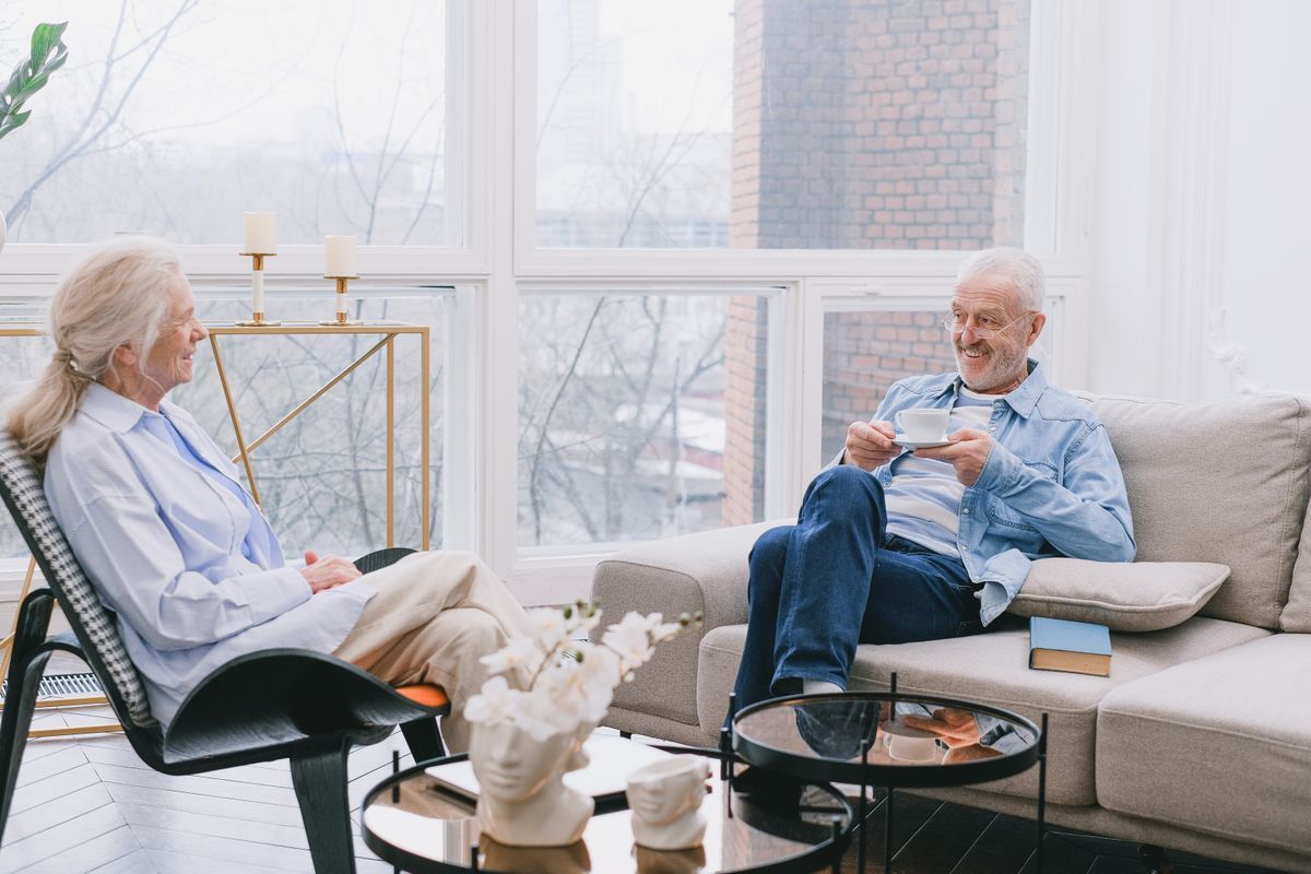 Two adults over 50 talking calmly over coffee at a table